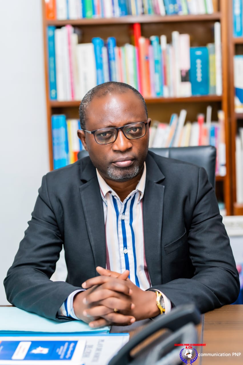 Dr. Justin B. Mudekereza seated at a desk during a civic engagement meeting